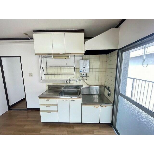 明るい日差しが差し込むキッチンは、調理時間を心地よく彩ります。収納も豊富で、機能的な空間です。
