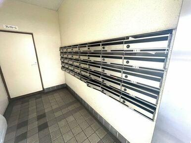 清潔感のある共用スペースに整然と並ぶ郵便受けは、管理体制の良さを感じさせます。住戸ごとに番号が明確