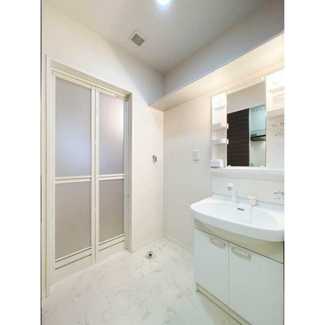 洗面台の横には洗濯機置場。脱衣所はちゃんと建具で仕切られております。また、上部には棚がございます！