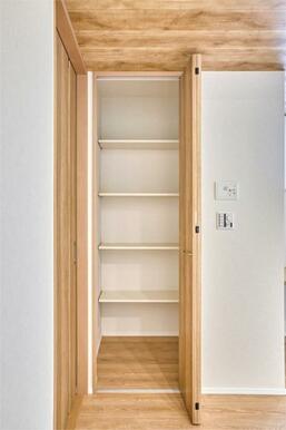 生活動線上に配された可動棚付きの収納庫。掃除道具や書類などリビングまわりの小物をすっきり収めます。
