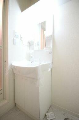 水栓金具はノズルが伸びるタイプ。トイレ同様、上部には収納棚が設置されています。