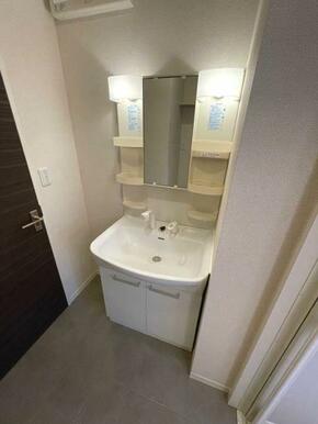 鏡の両脇に収納スペースを確保した洗髪洗面化粧台は、水栓がリフトアップするので洗髪もラクラク♪