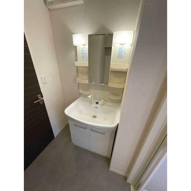 鏡の両脇に収納スペースを確保した洗髪洗面化粧台は、水栓がリフトアップするので洗髪もラクラク♪