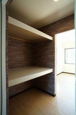 奥の主寝室とＬＤＫの間に設置された「ウォークスルークローゼット」は大きな収納空間。壁をシックな木目…