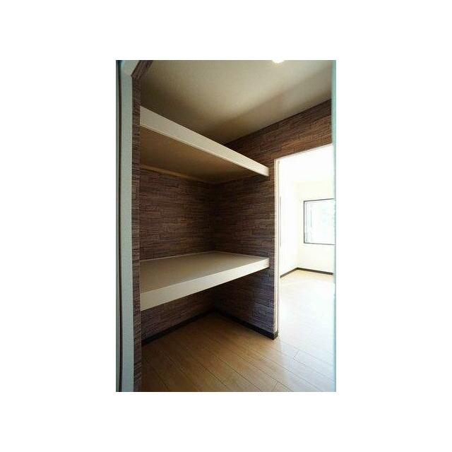 奥の主寝室とＬＤＫの間に設置された「ウォークスルークローゼット」は大きな収納空間。壁をシックな木目…