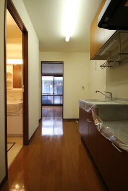 【キッチン】玄関から洋室方向。キッチンは吊戸棚付きで収納量も豊富！