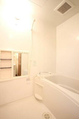 【浴室】ホワイトを基調とした清潔感溢れる浴室。壁面には収納棚も付いています。