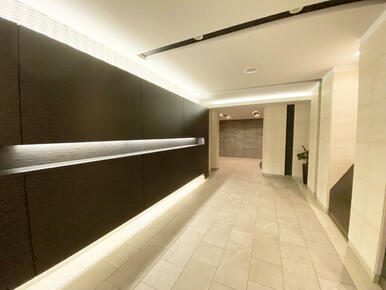 グランドエントランスは、エレベーターに向かって広がりのある空間と間接照明がステキです。