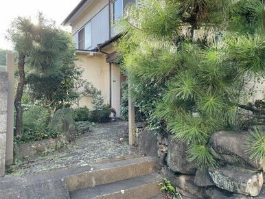 玄関までのアプローチが緑に囲まれており、訪れる人々を温かく迎え入れる空間としても魅力的です。手入れが