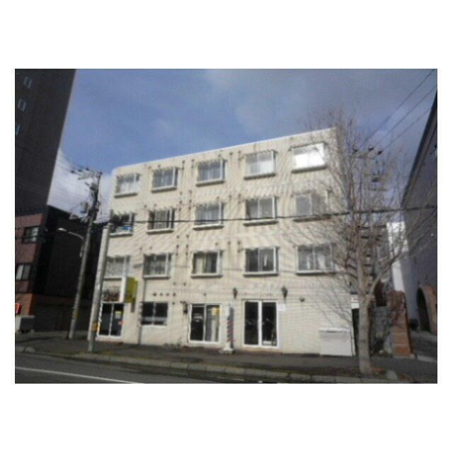 タイル張りの外観、１階は飲食店と美容室