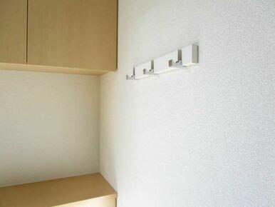 玄関にはコート等をかけられるフック付きです。