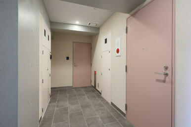 グレー×ピンクのカラーでまとめた落ち着いた雰囲気の共用廊下