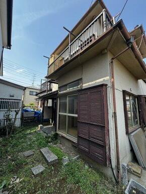 左側に位置する建物外観。1階部分に大きな掃き出し窓があります