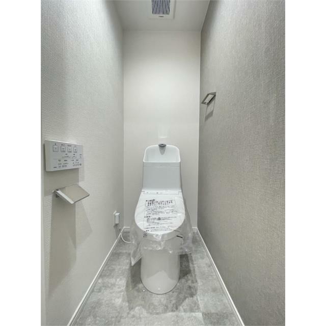 明るい壁紙と落ち着いたフロアがおしゃれなトイレ空間。温水洗浄便座付きで快適にお使いいただけます。換気