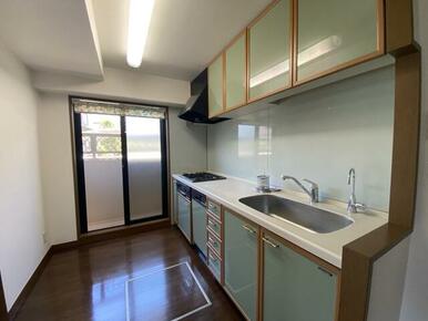 勝手口からの採光や通気性の良いシステムキッチンは、上棚収納や扉の緑色もステキです。