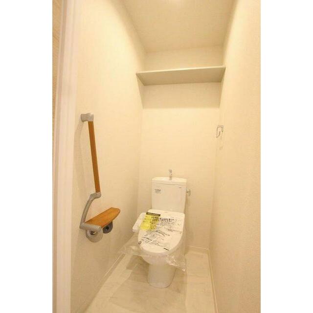トイレは暖房洗浄便座仕様。上部には収納棚が設置されています。