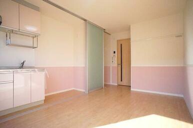 洋室（８．６帖）　キッチンはスライディングスクリーンで仕切られています。