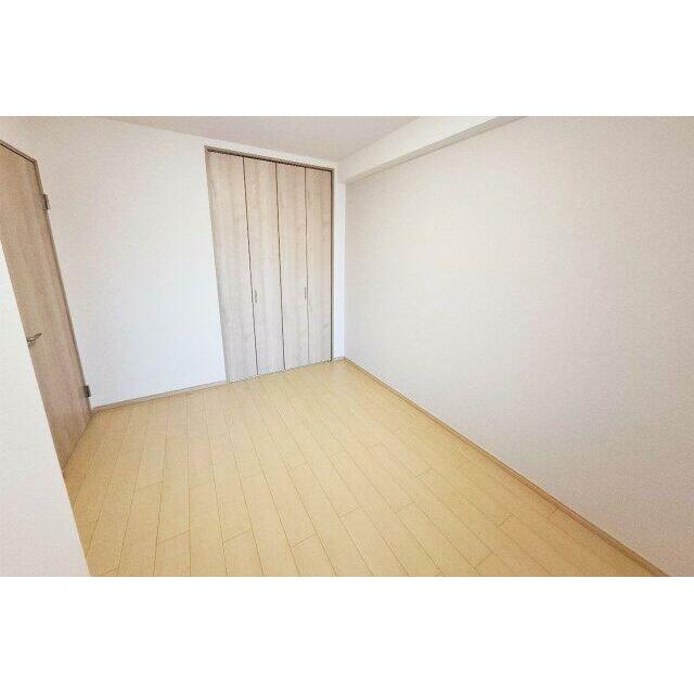 洋室1：新しく貼り替えたミルクティーカラーのアクセントクロスがあたたかみのある雰囲気を演出。