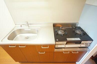 吊戸棚も付きキッチン。内装にあったブラウン色。そしてガスコンロは設備として設置されています。