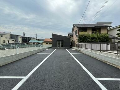 道路から駐車場と建物を望む