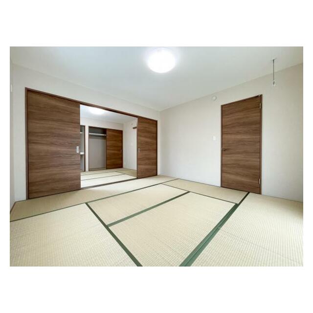 広々とした畳敷きの和室には、モダンな木目調の引き戸がアクセントに。