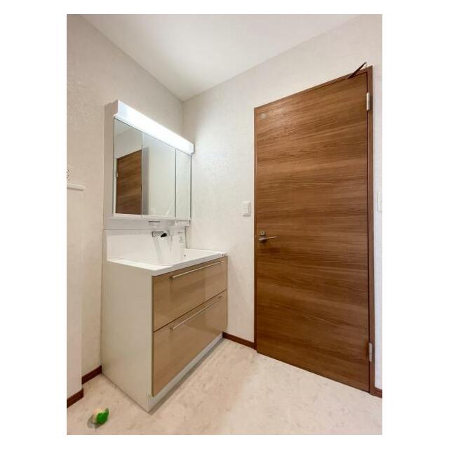 収納力のあるキャビネットと鏡上部の照明が機能的な洗面台です。