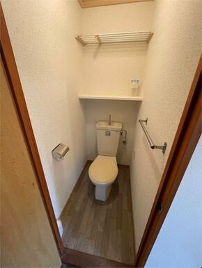 清潔感のあるトイレは、日々の暮らしを快適にします。収納棚と上部ラックも備わり、空間を有効活用できる設