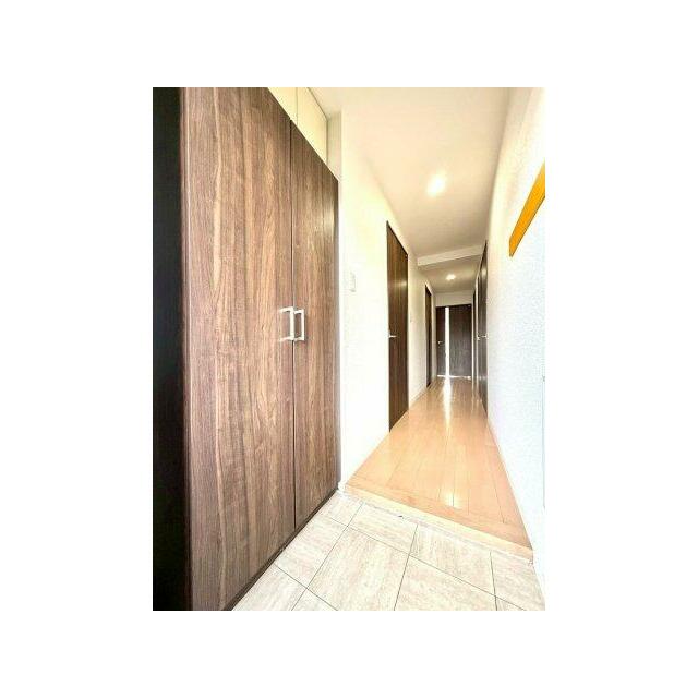 木目の建具と明るいフローリングが調和した清潔感ある玄関。収納も備え、住まいの第一印象を美しく整えます