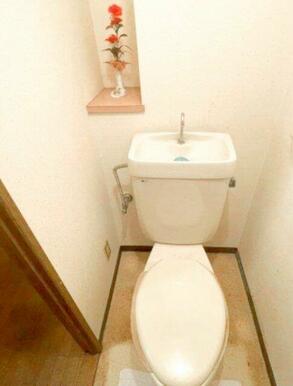 シンプルで清潔感のあるトイレスペース。背面には小物を置ける棚があり、芳香剤や装飾なども楽しめます。