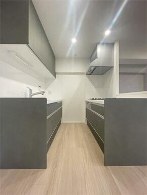 洗練されたダークグレーのキッチンは、スタイリッシュな空間を演出。明るい木目調のフロアが清潔感をプラス