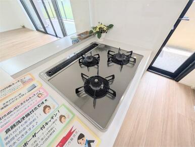 ３口コンロとグリルを備えたシステムキッチン。お料理を効率的に楽しめる対面式で、リビングダイニングを見