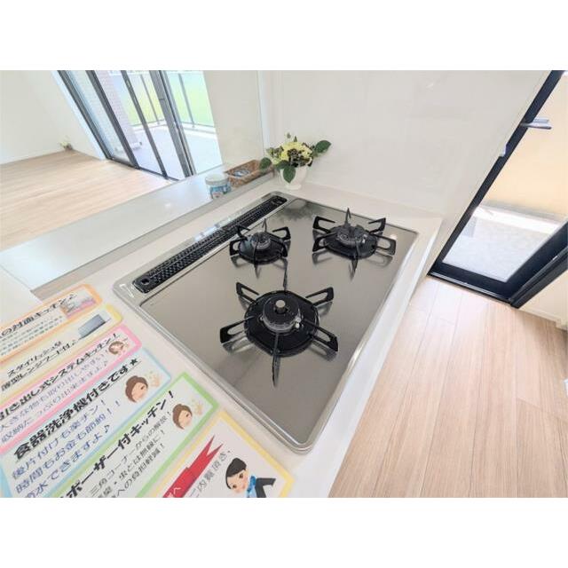 ３口コンロとグリルを備えたシステムキッチン。お料理を効率的に楽しめる対面式で、リビングダイニングを見