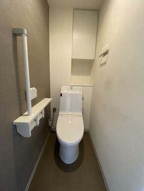 アクセントクロスがオシャレなトイレは、手摺りや収納棚も設置されています。