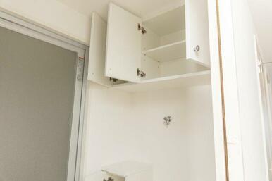 洗面所の洗濯機置き場の天井には、吊り戸棚が設置されています。普段使わないものや洗剤のストックなど