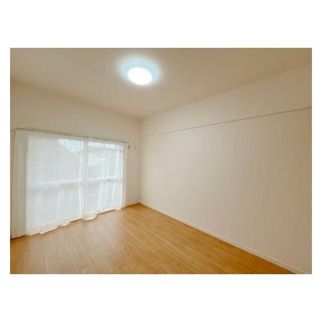 「北西側洋室　約5.7帖」バルコニーへ出られる窓にレースカーテンがございます。