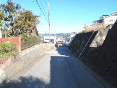 西側の接道（道路の南から北方面を撮影）※右側が物件です（擁壁含む）