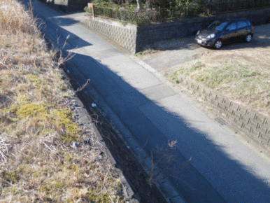 西側の接道（法面の上から道路を撮影）　※左側が物件です