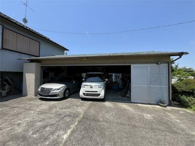 住宅の前に屋根付きの駐車場（車庫）があります。