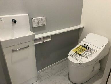 １階　節水機能付きタンクレストイレ。カウンターと手洗い器付き。
