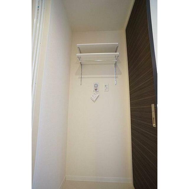 洗面所　室内洗濯機置き場。上部には棚がございます。