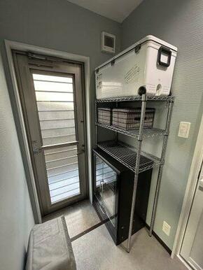 キッチンとは別に勝手口を備え、室内土間で靴を脱げます。カーペット敷きの洋室へ直接アクセス可能です。