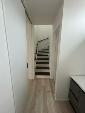 ダークカラーの手すりがお洒落でアクセントになる階段。階段窓から陽光が差し込み、明るく開放的な設計です