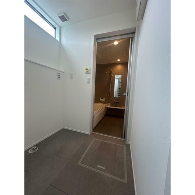 高窓から陽が差し込む明るい脱衣室。洗濯機置き場からお風呂へ直行できる効率的な動線で、家事もラクです。