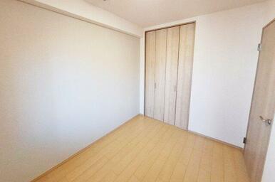 洋室2：貼り替えたベージュカラーのアクセントクロスで落ち着いた雰囲気。シンプルさが魅力。